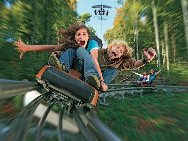 Zwei Kinder in der Sommerrodelbahn