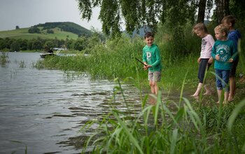 Kinder spielen am See