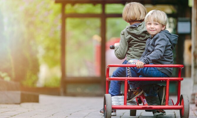 Kinder auf Kinderfahrzeug im hoteleigenen Fuhrpark