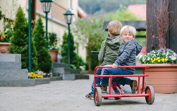 Zwei kleine Buben am Tretroller