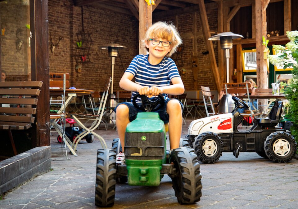 Junge fährt auf Spielzeug-Traktor