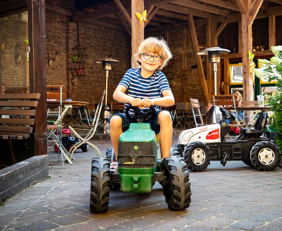 Junge fährt auf Spielzeug-Traktor