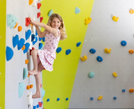 Mädchen beim Klettern auf der Kletterwand