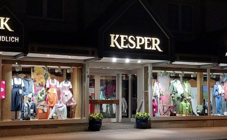 Beleuchtete Schaufenster von Kesper mit ländlicher und aktiver Kleidung bei Nacht