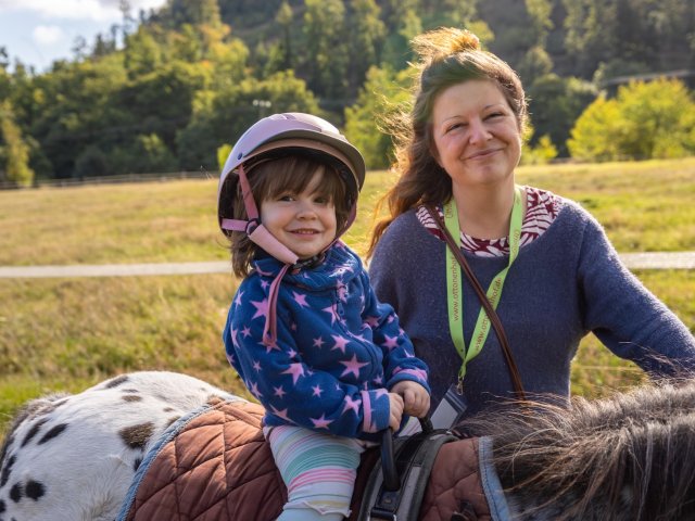 Kind auf Pony lacht in die Kamera