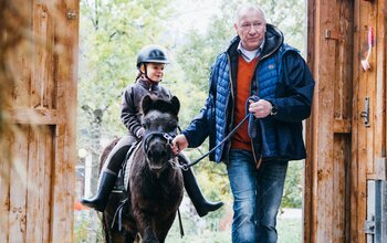 Mädchen sitzt am Pony