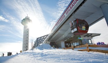 Seilbahnstation Ettelsberg mit Gondeln und Aussichtsturm bei sonnigem Winterwetter
