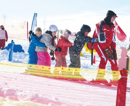 Kinder beim Skikurs auf der Piste